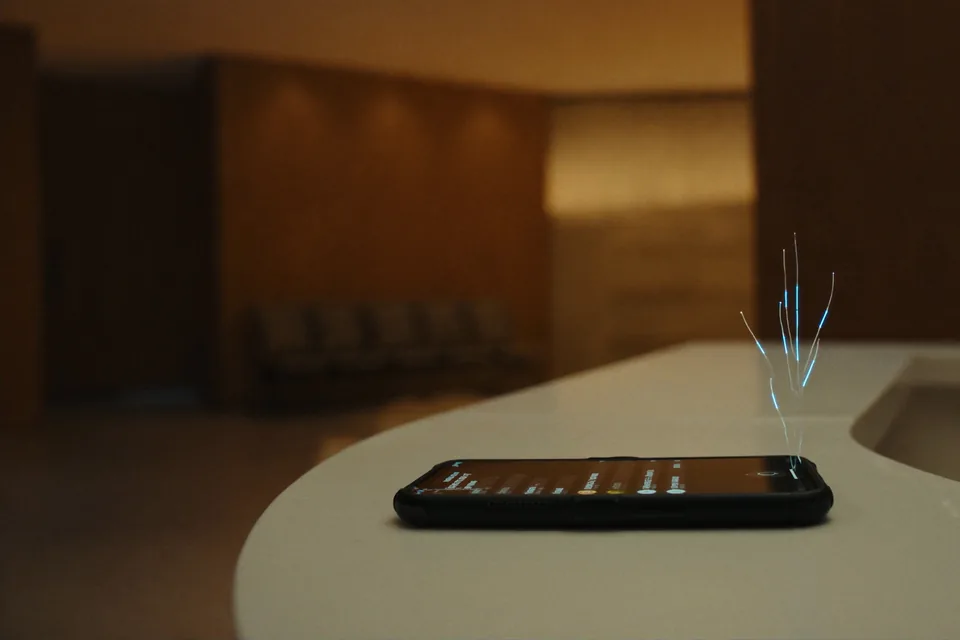 A phone lies on a dental clinic reception counter, a few threads of light rising from it
